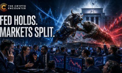 Brokers and market participants react on a busy trading floor as a bull and bear clash in the background following the Federal Reserve’s divided 9-3 decision to hold interest rates steady.